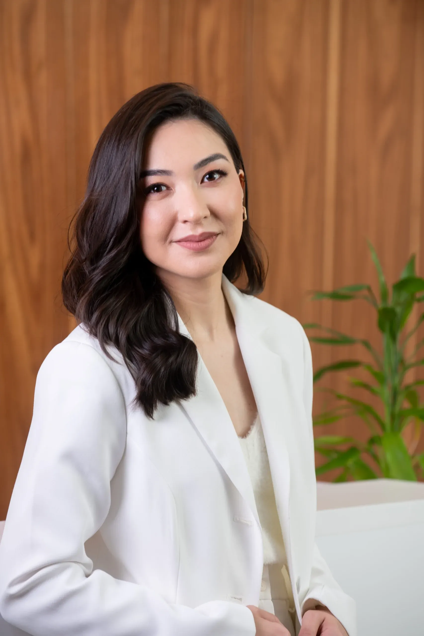 Dra. Giulia Godoy no consultório, de blazer branco